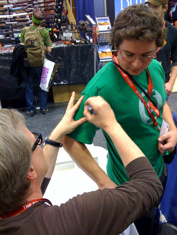 Bruce Timm signing a fans Green Lantern shirt at the Flesk Publications booth at WonderCon. Photo by Josh Ford.